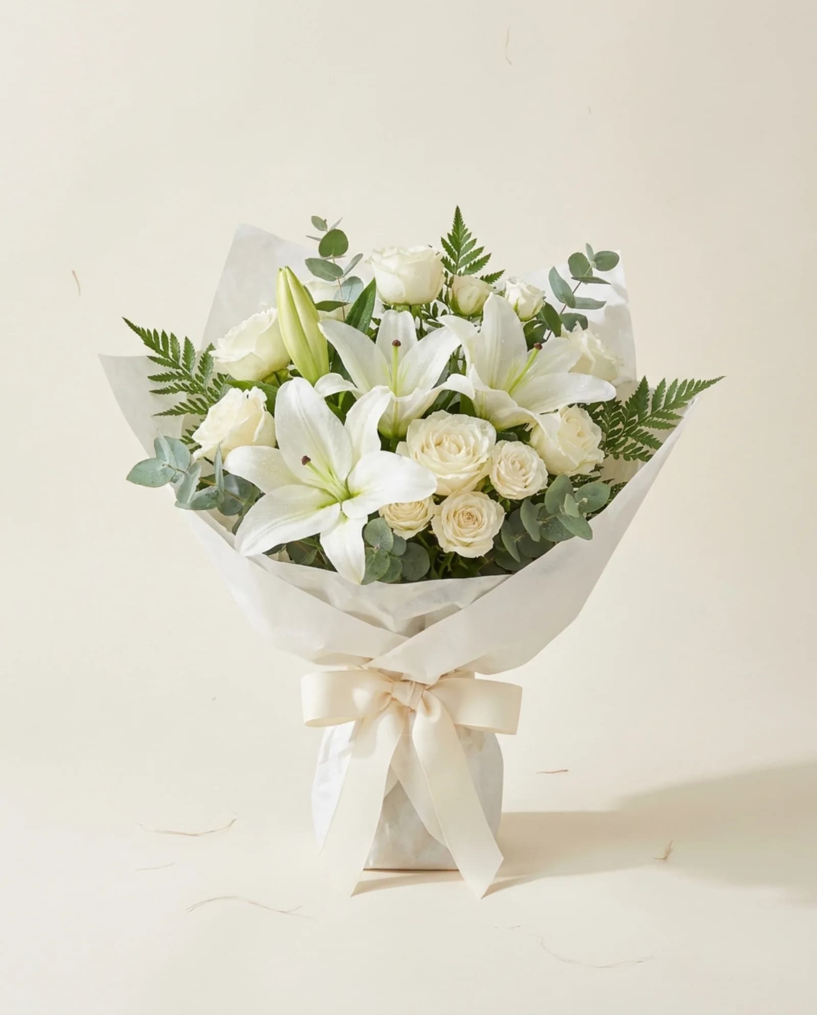 Lírios brancos e rosas, com cartão de condolências.